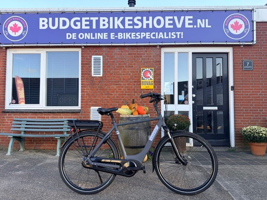 De bronfoto: e-bike voor een winkelpand met bankje