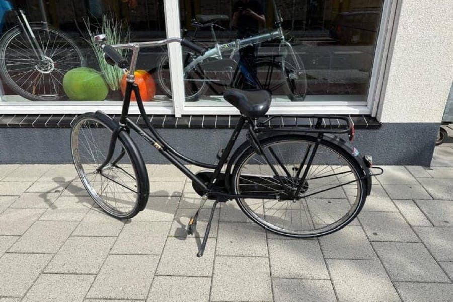 Damesfiets op de stoep voor een etalage